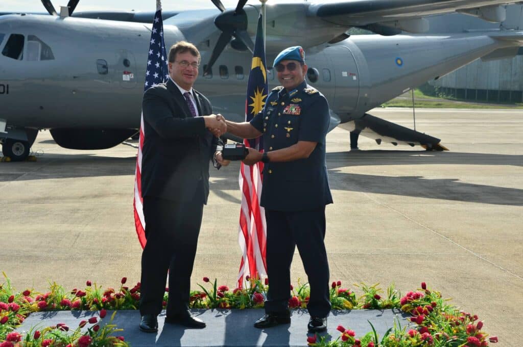 السفير الأمريكي لدى ماليزيا إدجارد كاجان يسلم وحدة التحكم اليدوي العالمية (UHCU) لبرج المستشعر الكهروضوئي/الأشعة تحت الحمراء للطائرة قائد القوات الجوية الملكية الماليزية الجنرال تان سري داتو سري محمد أصغر خان بن جوريمان خان (القوات الجوية الملكية الماليزية)
